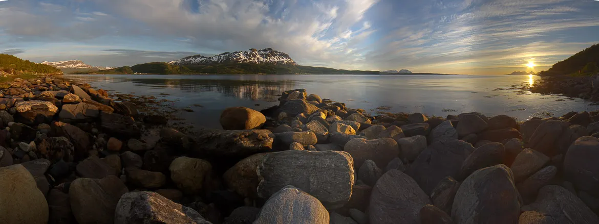 The midnight sun over a rocky shore