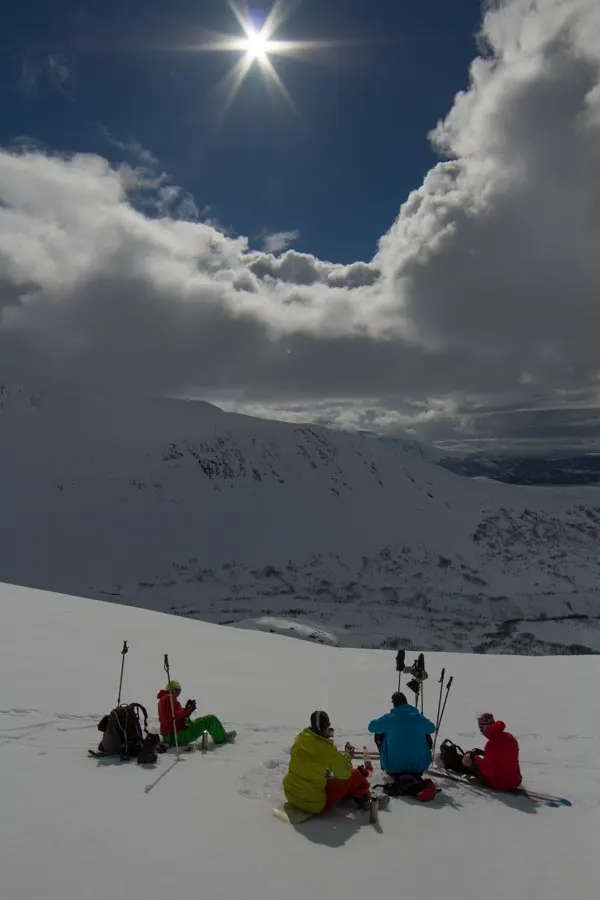 A group resting on a sunny snow slope